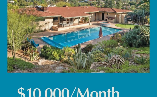 Mid-century home with red tile roof, covered patio, and rectangular swimming pool surrounded by desert landscaping and mountains in background