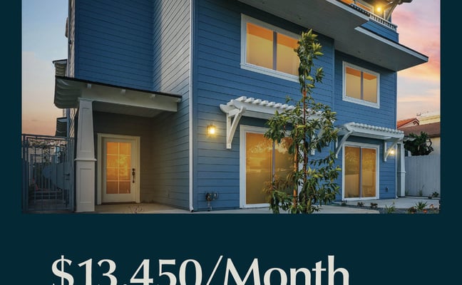 Modern blue two-story house with lit windows at dusk, metal railings, and climbing vines